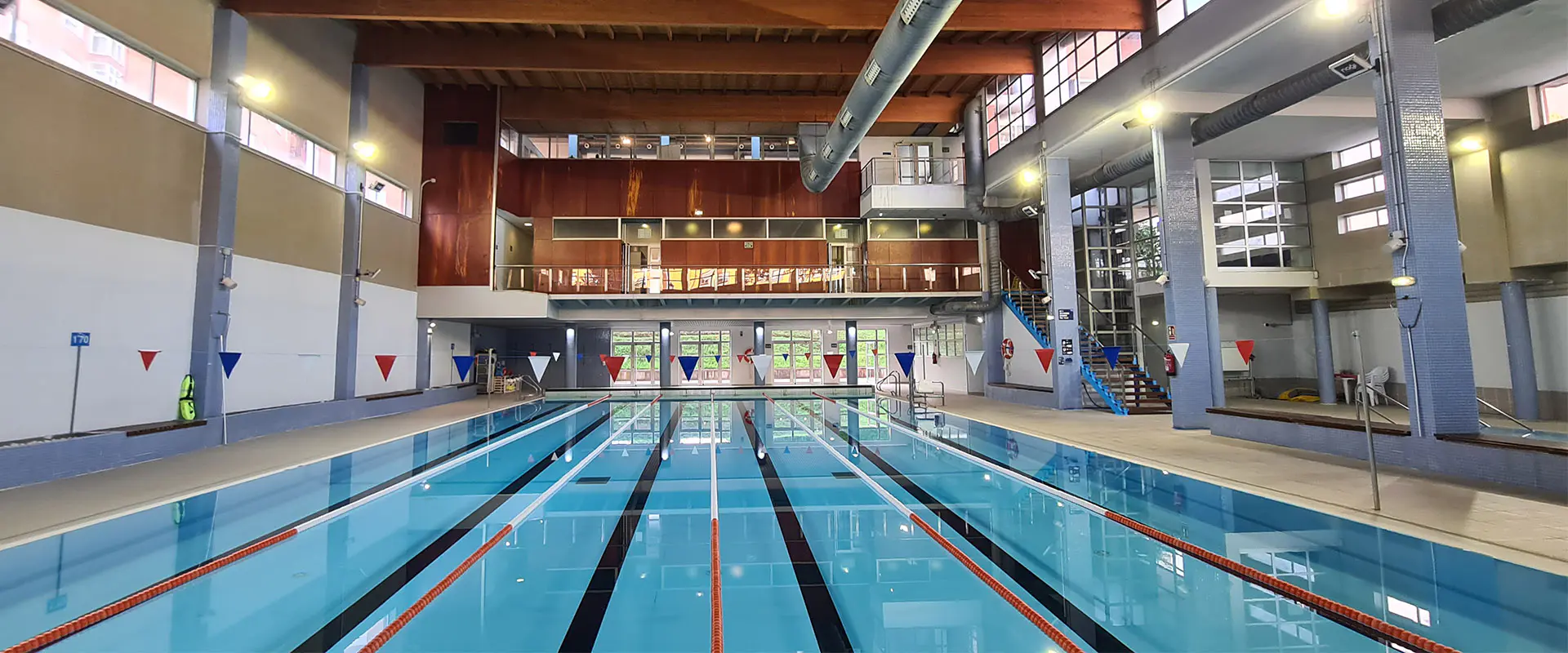 Panorámica de la piscina principal, con vista frontal de sus 6 calles. Al fondo, piso superior y escaleras de acceso