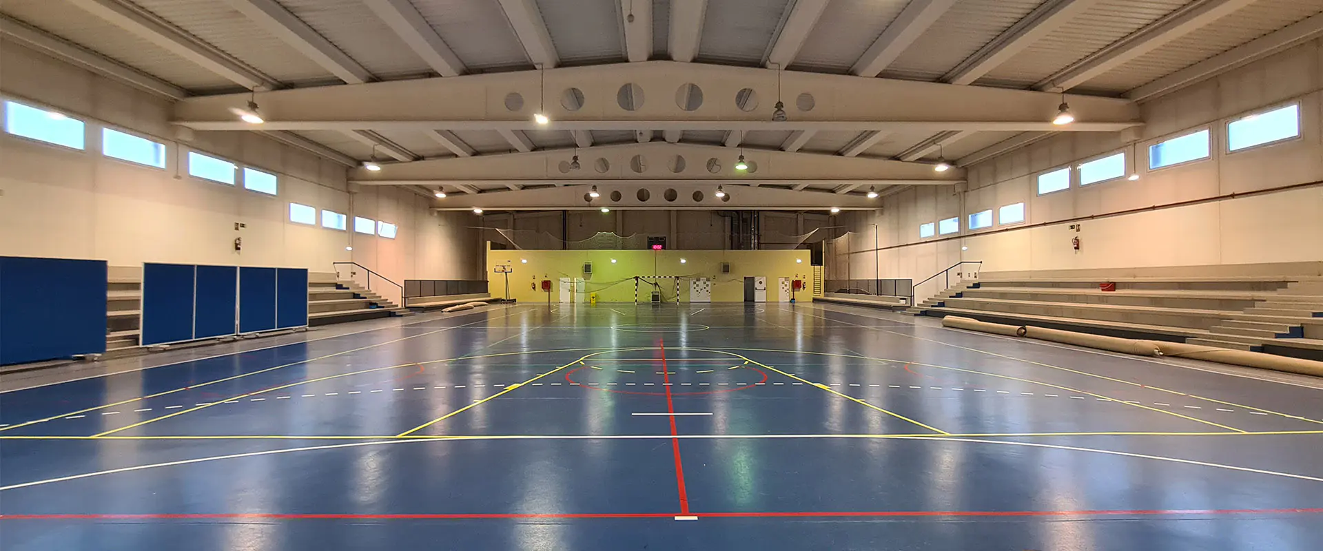 Pista polideportiva, con una portería de fútbol sala al fondo y gradas en los laterales