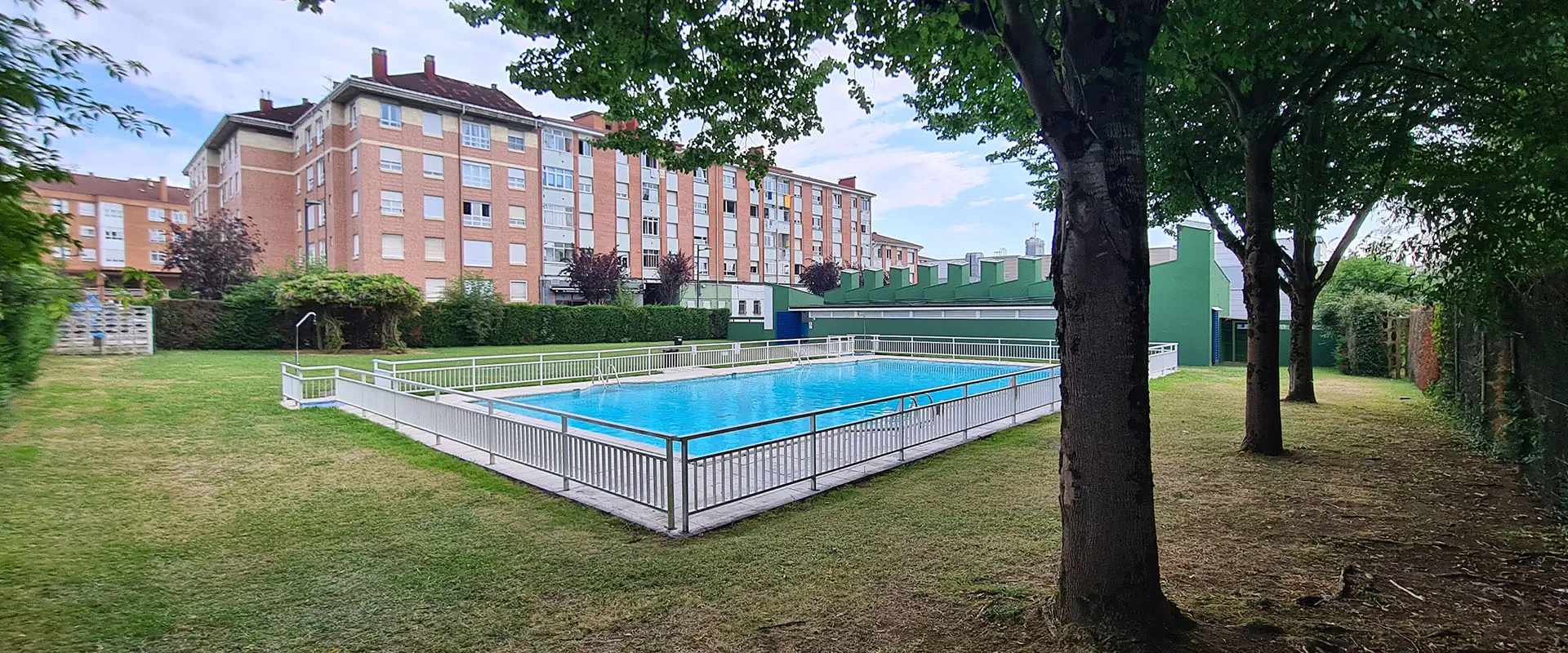 vista de la piscina desde una zona arbolada de la playa
