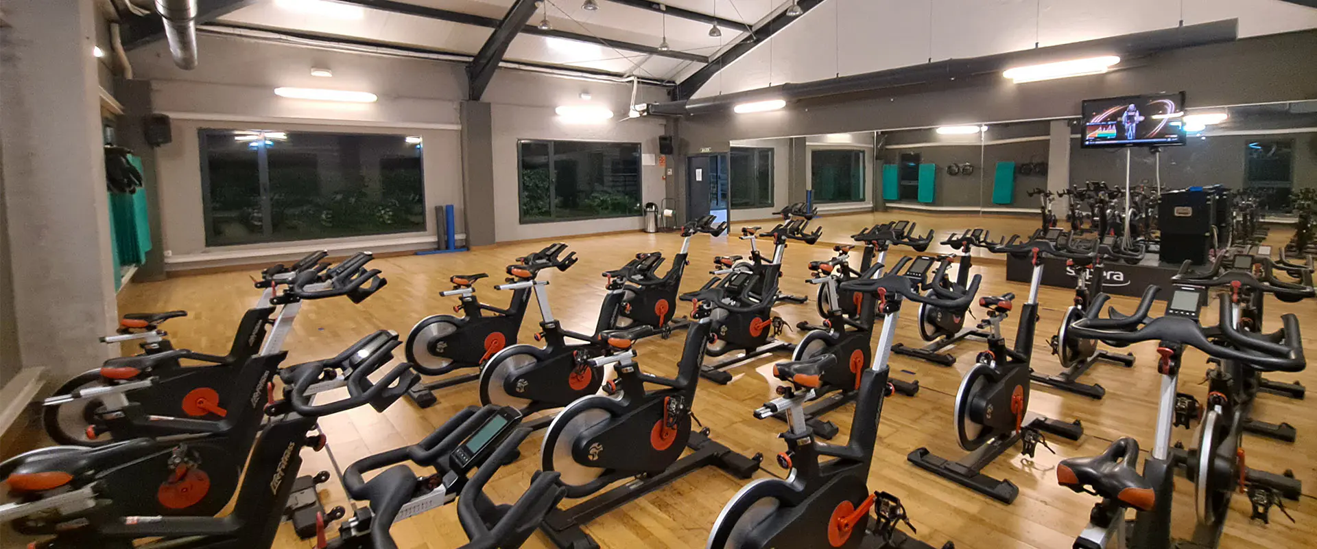 Sala de "bike", con vista panorámica de las bicicletas estáticas y grandes ventanales alrededor de la sala