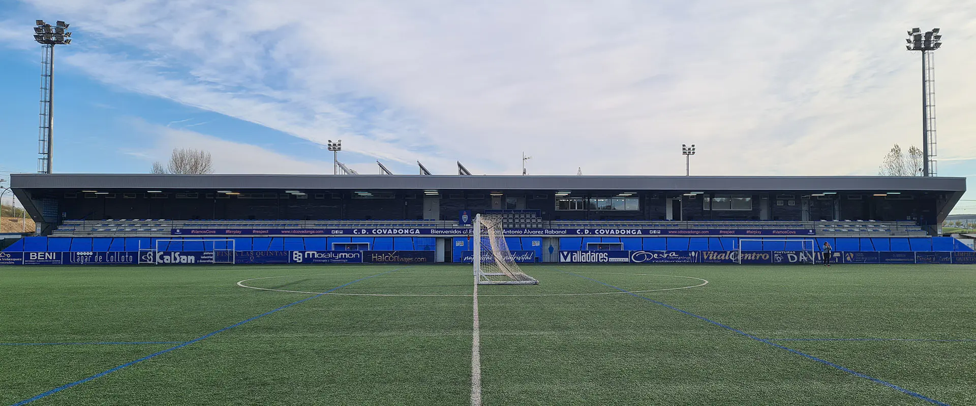 Terreno de juego a pie de campo. Línea divisoria central. Portería en el medio del campo. Gradas al fondo