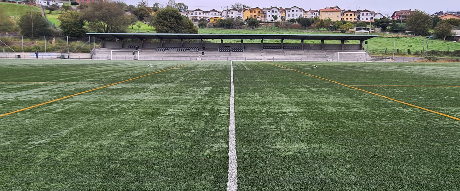 Terreno de juego a pie de campo. Gradas al fondo