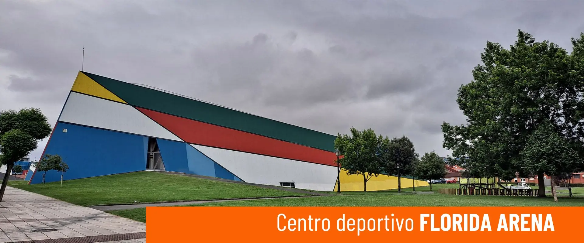 Imagen del Centro Deportivo Florida Arena. Lateral exterior del edificio, con zonas verdes a su alrededor 