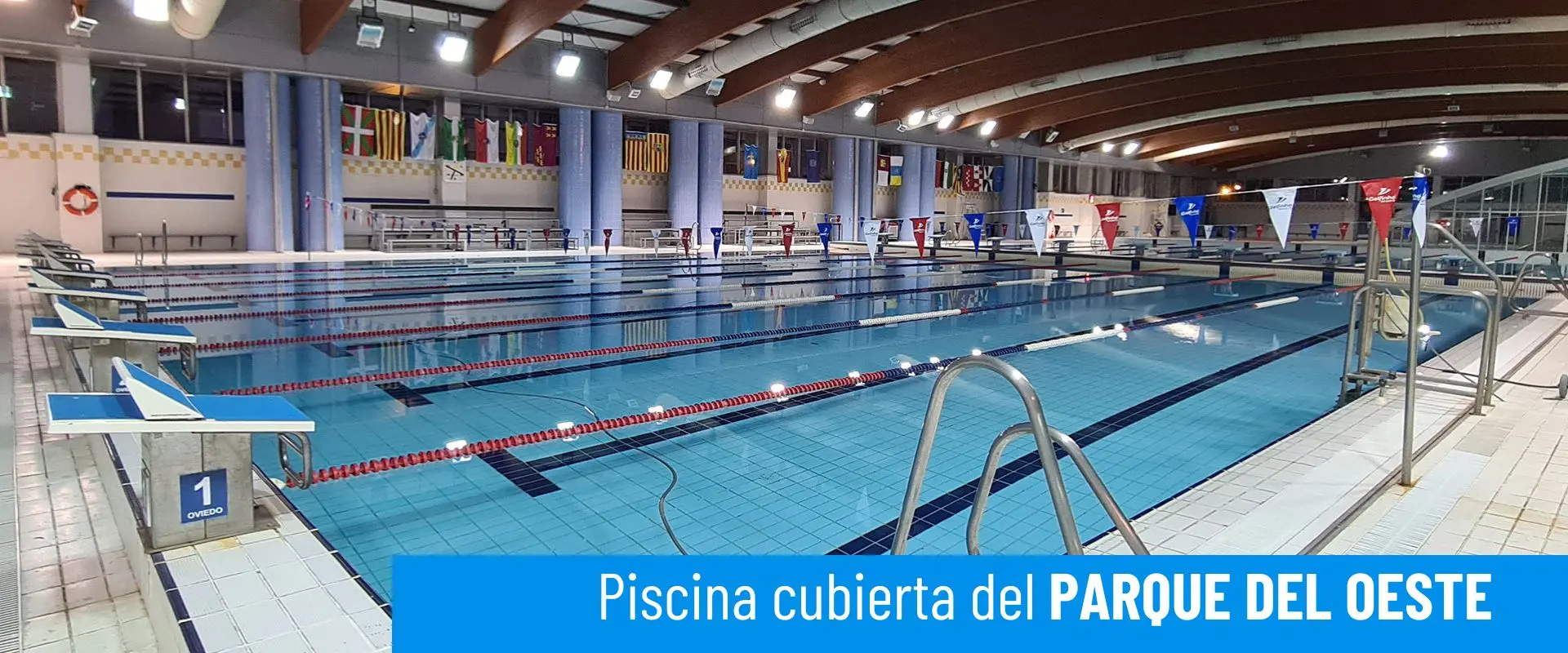 Piscinas cubiertas del Parque del Oeste. Vista lateral de la piscina olímpica. Barandilla de acceso y plataformas de salida 