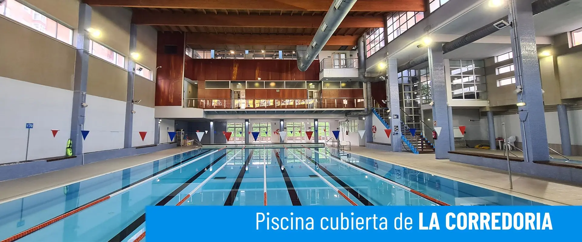 Piscinas cubiertas de La Corredoria. Vista frontal de la piscina principal con sus 6 calles. Escaleras al piso superior 
