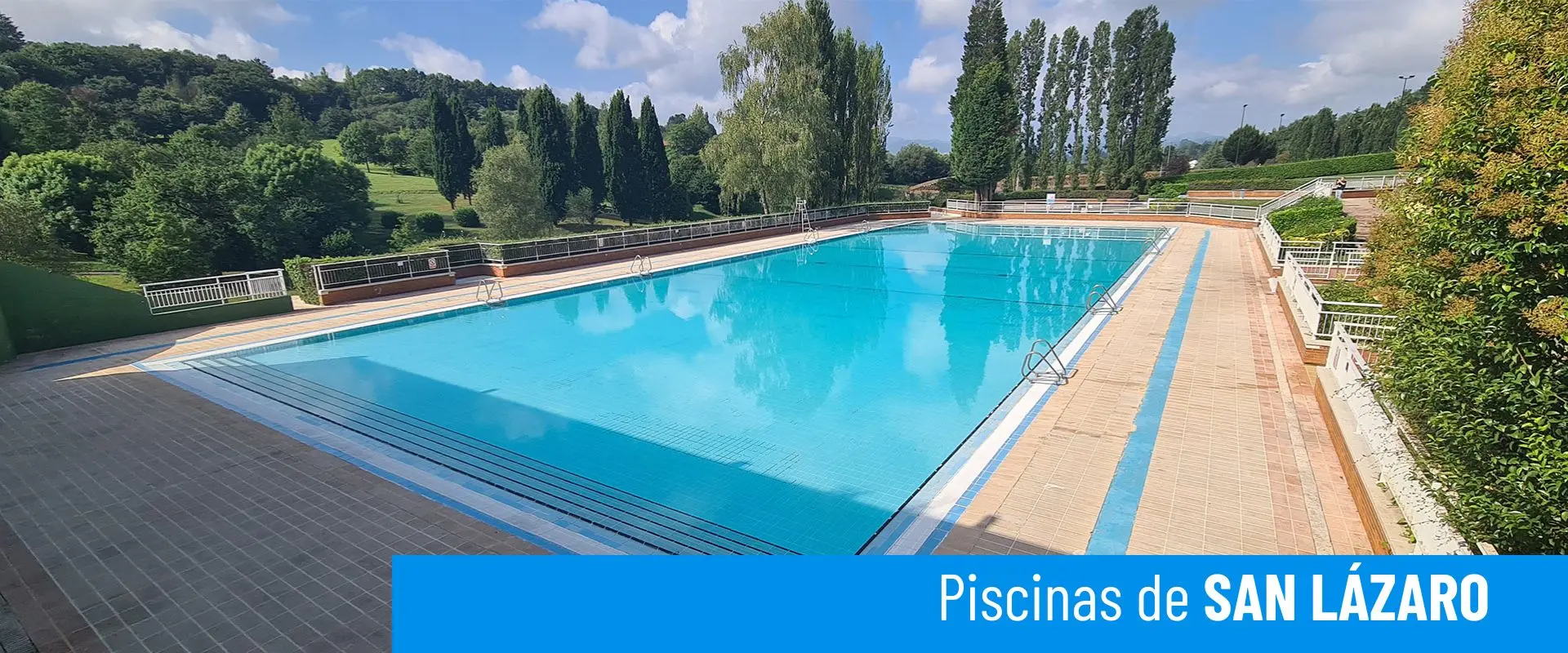 Piscinas de San Lázaro. Vista de la piscina principal, rodeada de vegetación. Vistas al Parque de Invierno 