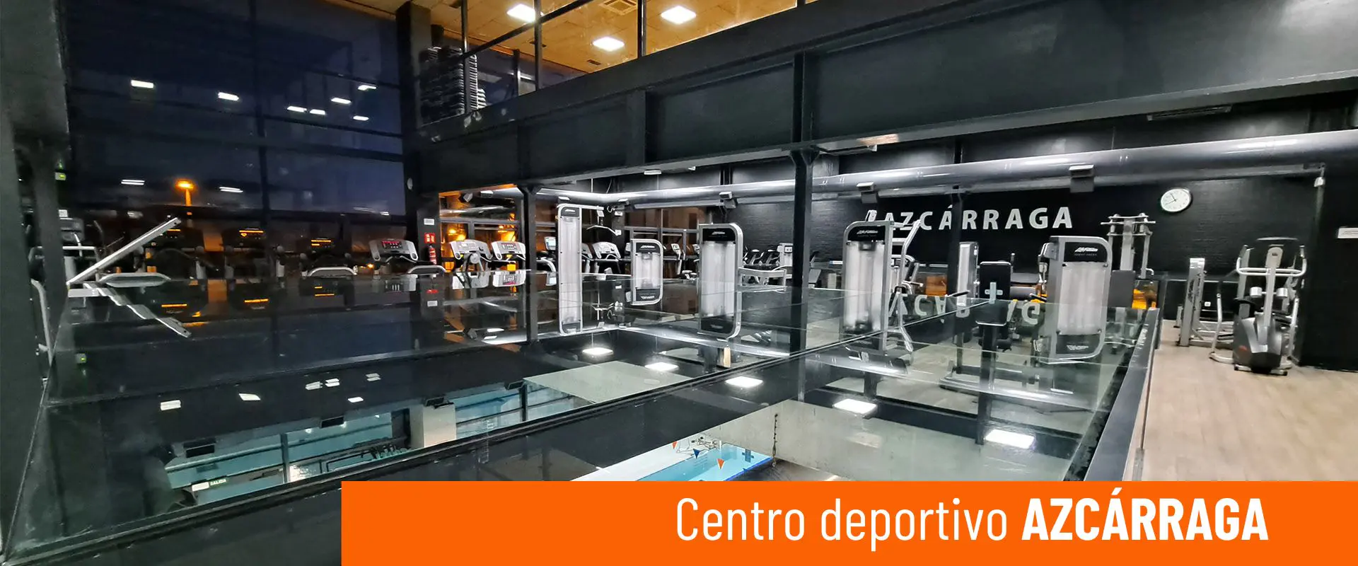 Centro deportivo Azcárraga. Sala de fitness. Diversas máquinas de ejercicio. Vista parcial de la piscina del piso inferior 