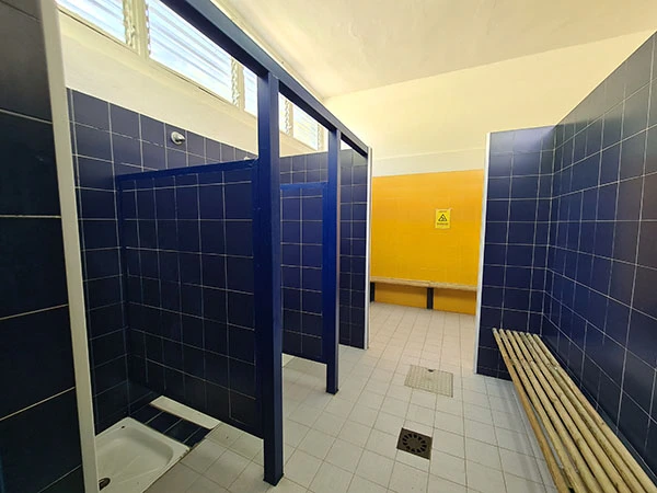 vista de un vestuario con banco y duchas