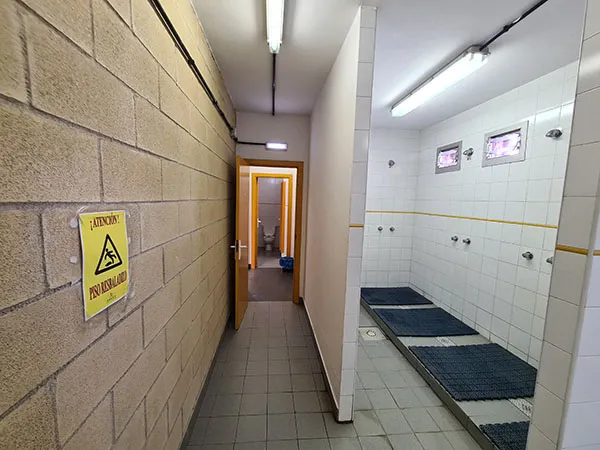 vista del pasillo de un vestuario con las duchas a la derecha