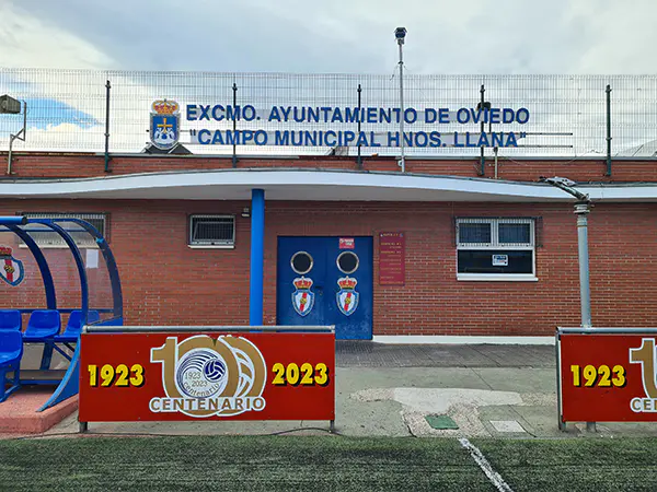 Fachada de un edificio de servicios, con letrero en la parte superior con el nombre de la instalación y el escudo de Oviedo
